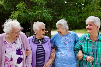 Four residents laughing together outdoors