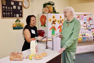 Staff member serving a resident in a friendly setting