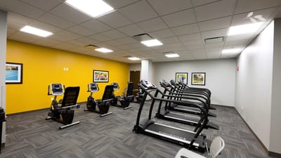 Bright fitness room with exercise equipment and artwork