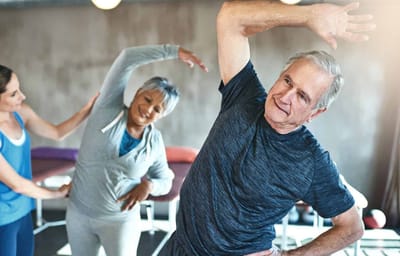 Residents participating in a group stretching activity