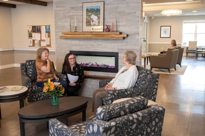 Residents and staff engaged in conversation in a lounge area