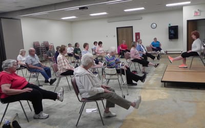 Residents participating in a seated exercise class