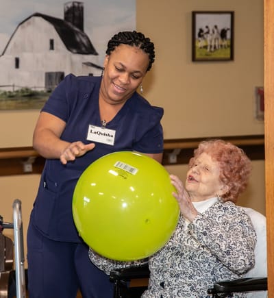 Staff member engaging with a resident during an activity