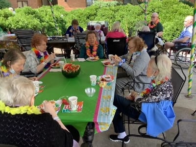 Residents enjoying a meal outdoors during a festive gathering