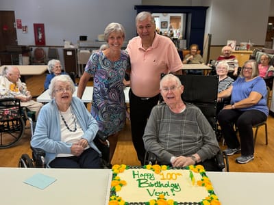 Residents celebrating a 100th birthday party with cake