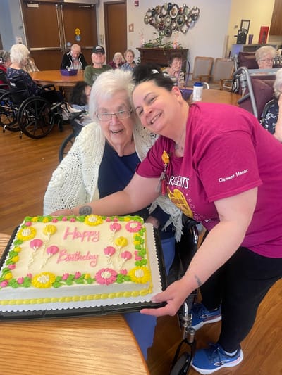 Resident celebrating birthday with staff and cake