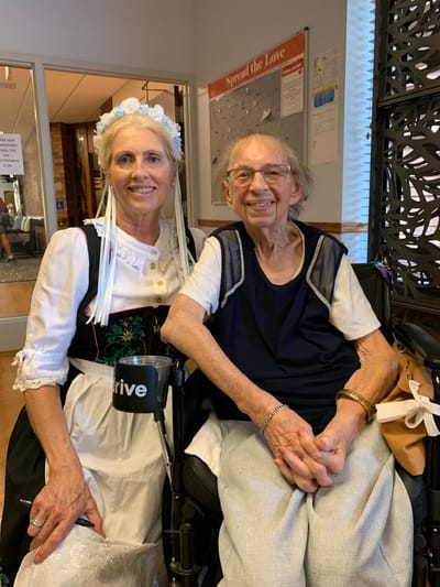 Resident and staff member smiling together in a common area