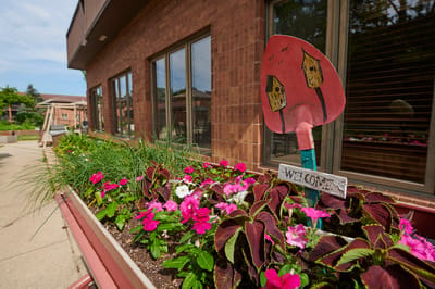 Colorful flower bed with welcome sign outside