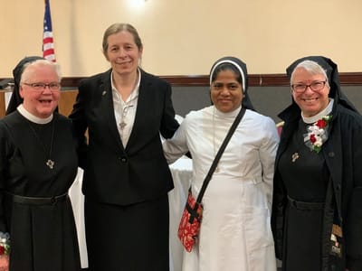 Four staff members smiling together at an event