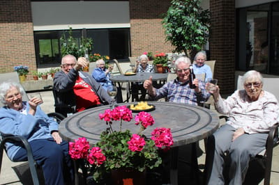 Residents enjoying a sunny day outdoors with snacks