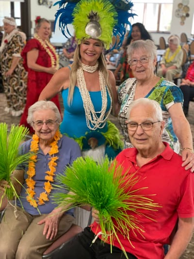 Residents enjoying a lively luau performance in a common area