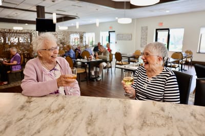 Two residents enjoying drinks in a common area