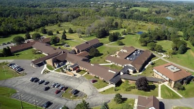 Aerial view of a senior living facility surrounded by greenery
