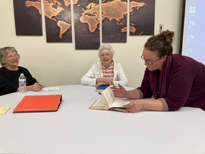 Residents and staff engaged in a reading activity.