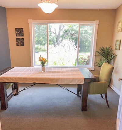 Bright, cozy common area with a table and chairs