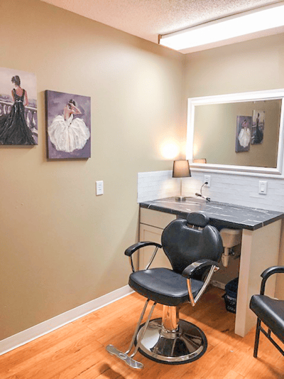 Interior of a hair salon space with styling chair and artwork