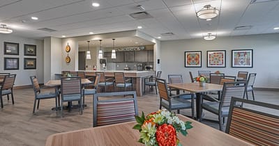 Bright dining room with tables and kitchen area