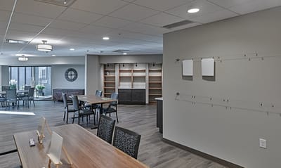 Bright common area with tables and seating for residents