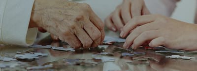 Hands assembling a puzzle together