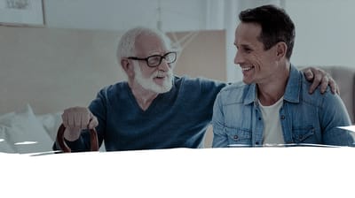 A senior man and a visitor smiling together