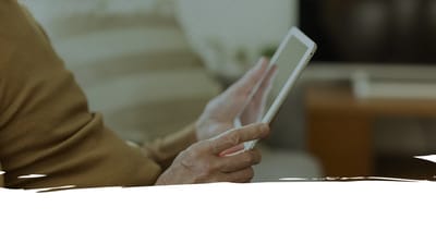 Hands holding a tablet in a soft focus setting