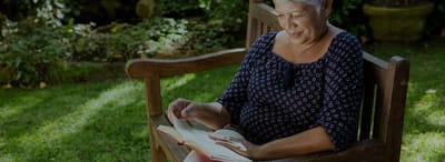 Woman reading a book in a garden
