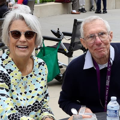 Two smiling residents enjoying time together outdoors