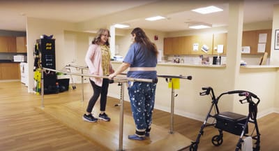 Therapist assisting resident on a therapy ramp