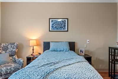 A cozy resident room with a bed and artwork
