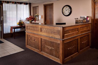 Reception area with wooden front desk and clock