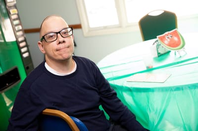 Resident playing bingo at a green table in an activity room