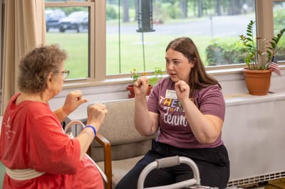 A staff member assisting a resident with exercises