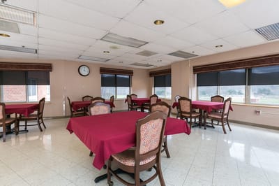 Bright dining room with tables covered in red tablecloths