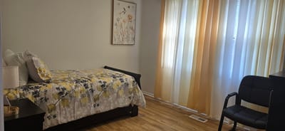 Cozy private resident room with floral bedding and chair