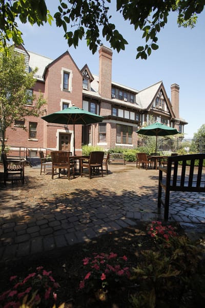 Exterior view of a nursing home with outdoor seating