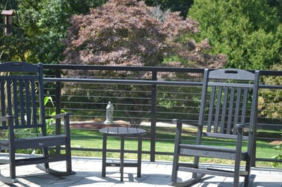 Two rocking chairs on a patio with garden view