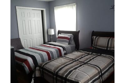 Two twin beds in a light-filled room with gray walls