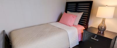 Cozy private resident room with bed and lamp