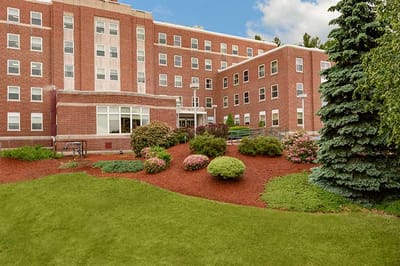 Exterior view of The Highlands assisted living facility with gardens
