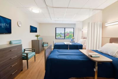 A well-lit interior room with two beds and modern decor