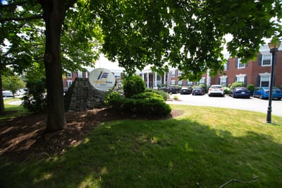 Facility logo sign with building in background