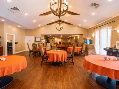Bright common area with orange tablecloths and chairs