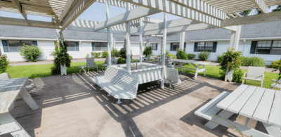 Outdoor shaded seating area with white benches