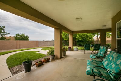 Covered patio area with seating and garden view