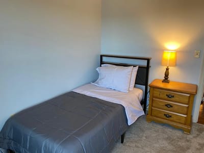 Cozy single bedroom with bedside table and lamp