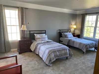 A private resident room with two beds and natural light