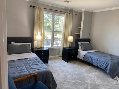 A comfortable resident room with two beds and light decor
