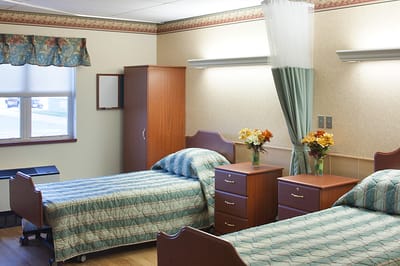 A well-furnished resident room with two beds and decor