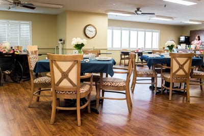 Dining area with residents and tables set for meals