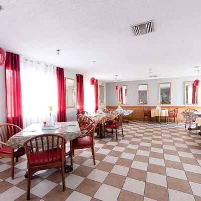 Bright dining area with checkered flooring and red accents